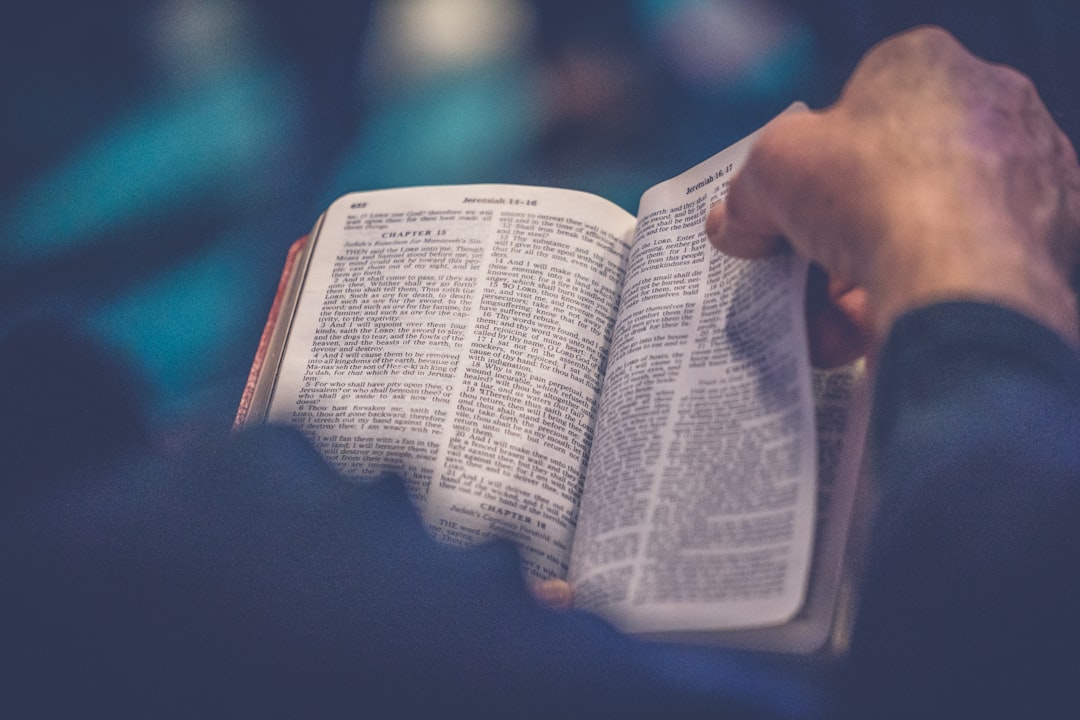 Hands turning the page of an open Bible
