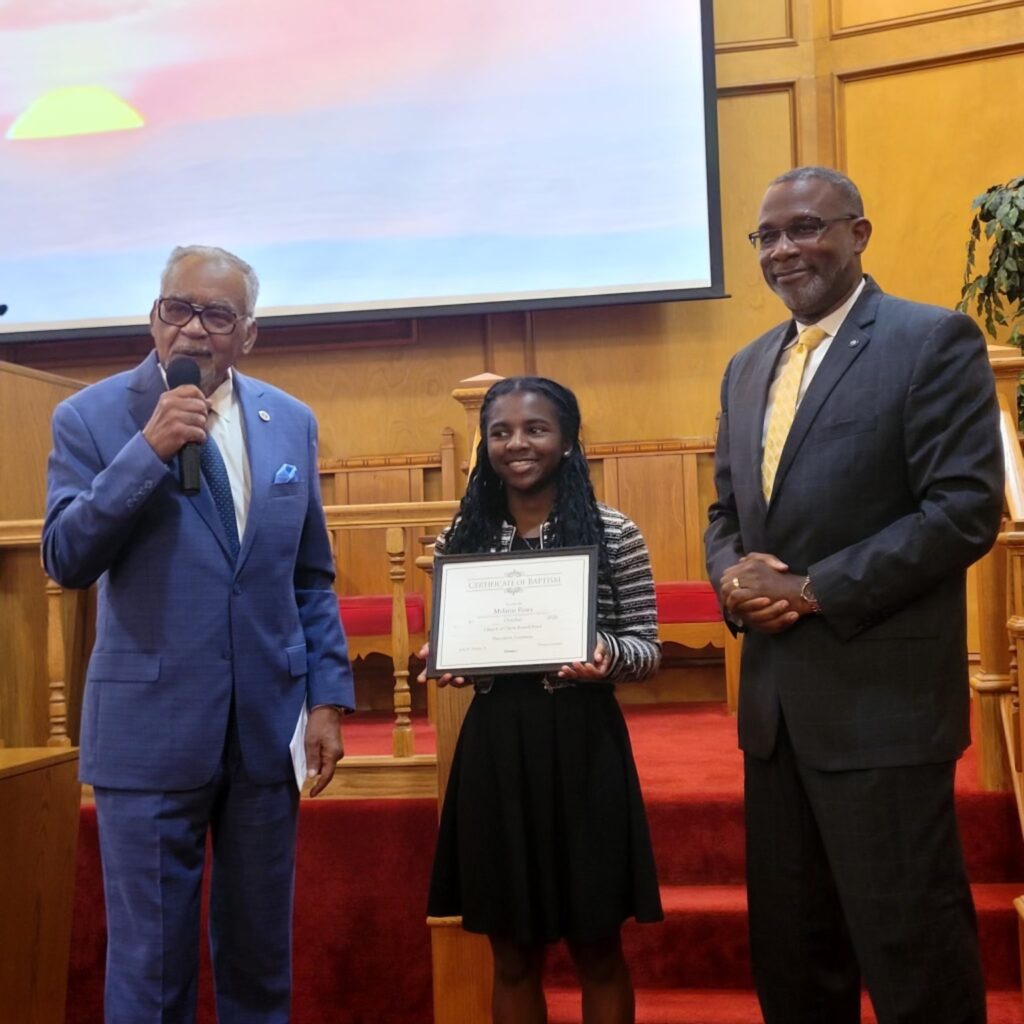 Melanie Posey holding her baptism certificate at Russell Road Church of Christ.